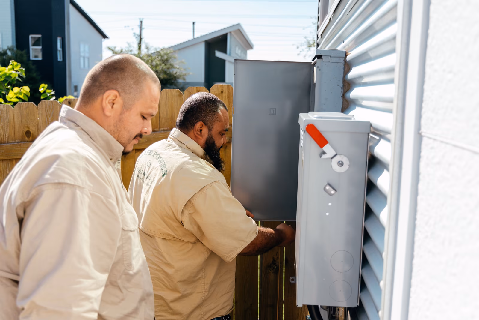 Two people shaking hands while unloading Base Power equipment