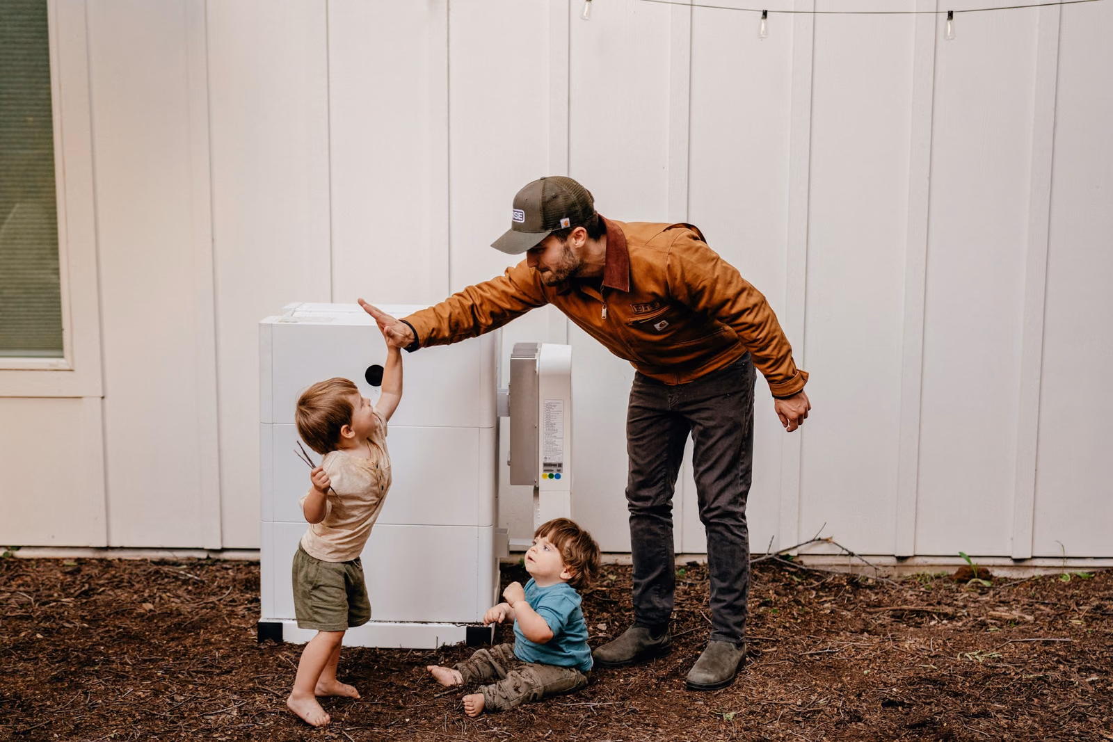 A dad and his kids beside their Base Power battery
