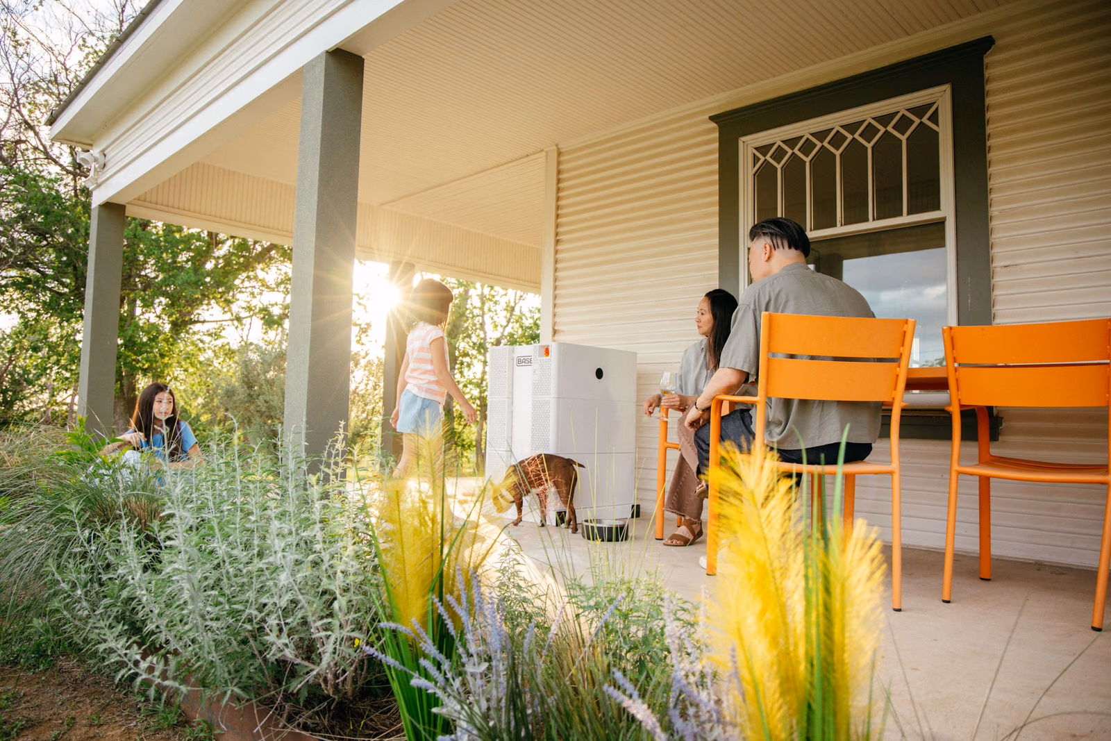 A family relaxing outside their home with a Base Power battery